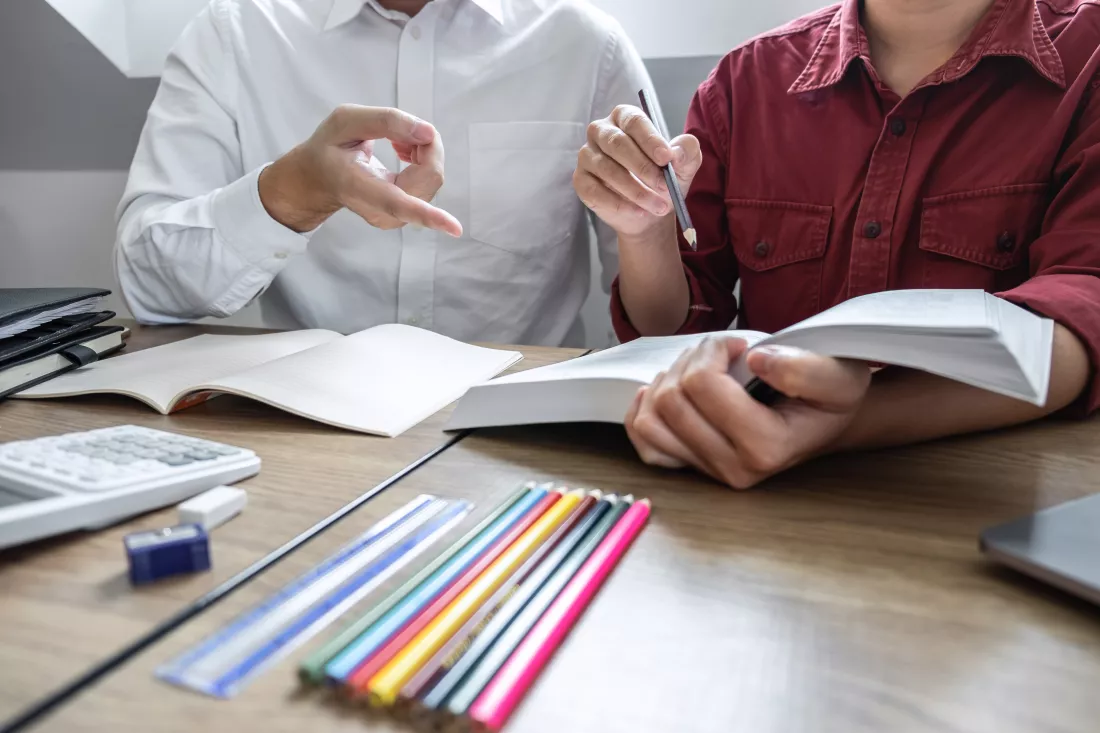 high-angle-view-man-woman-discussing-while-reading-book-table