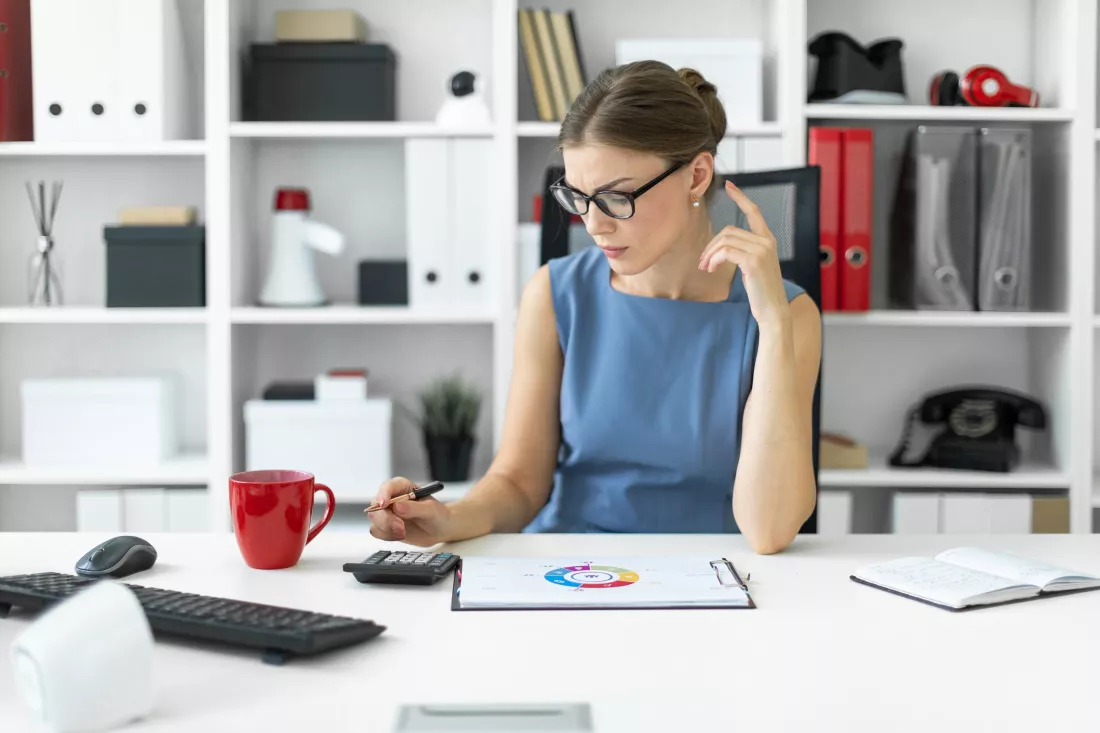 young-girl-is-sitting-desk-office-holding-pen-her-hand-counting-calculator-before-girl-lies-sheet-with-diagram